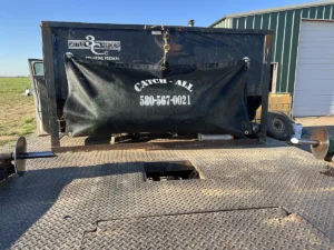The Catch All, a durable woven nylon net, secured on a pickup bed to prevent net wrap and feed stacks from blowing off during transport, perfect for environmentally friendly farming.