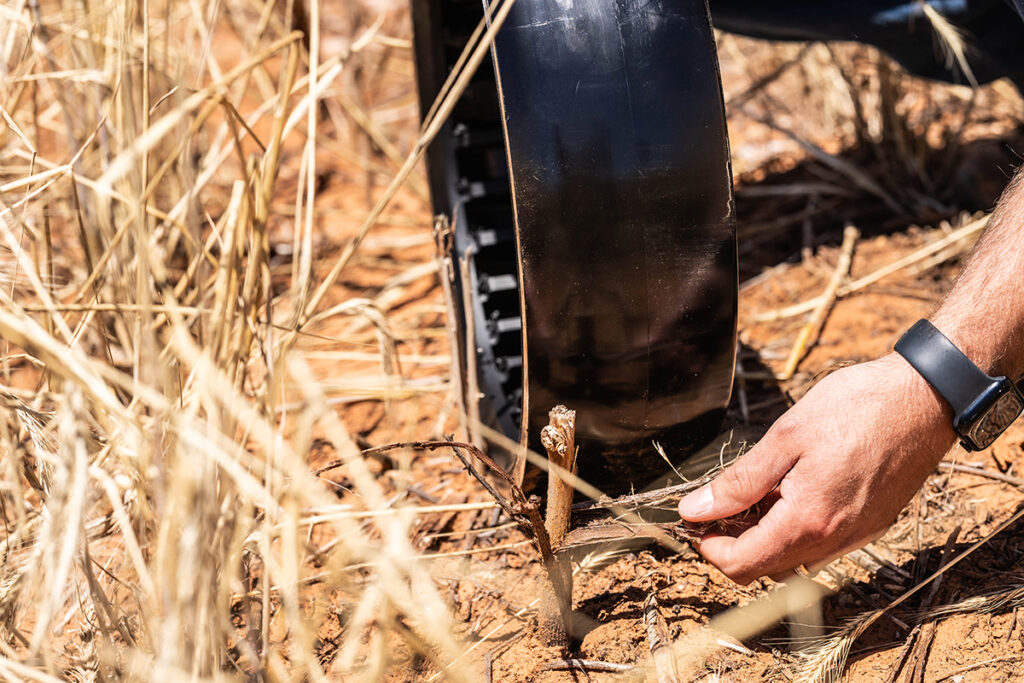Close-up of gauge wheel pressed into dry no-till soil during test