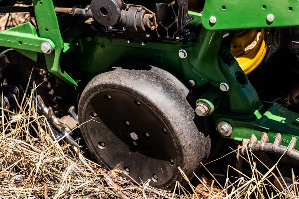 Gauge wheel mounted on no-till planter running through straw residue