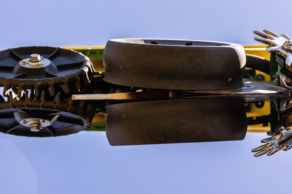 View of gauge and closing wheels on planter row unit from below