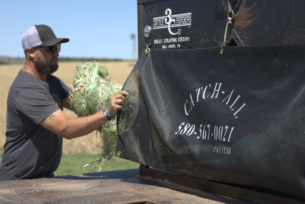 Rancher discards hay bale net wrap into Catch All on a flatbed truck.