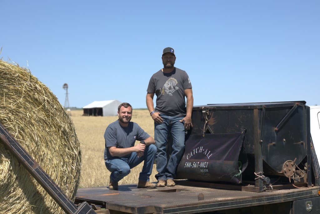 Two farmers with the Catch All net wrap solution on a flatbed during hay season.