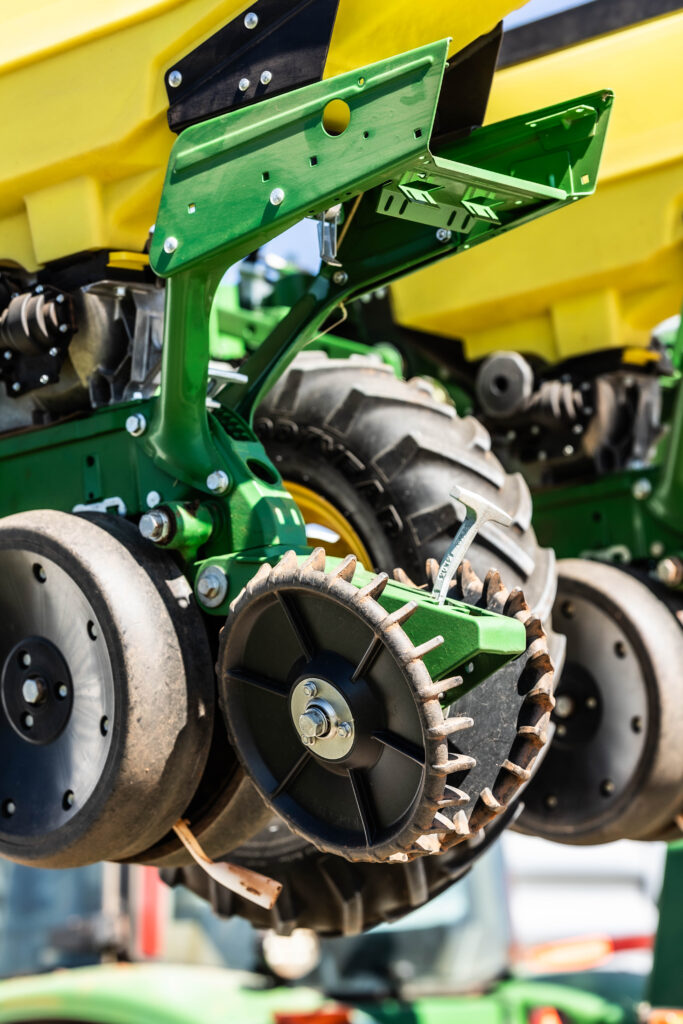 Mounted planter closing wheels on modern farming equipment for no till planting and improved seed-to-soil contact.