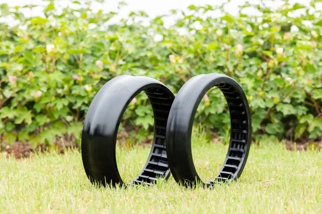 4AG Manufacturing gauge wheels displayed on grass in front of cotton field showing durable no-till design