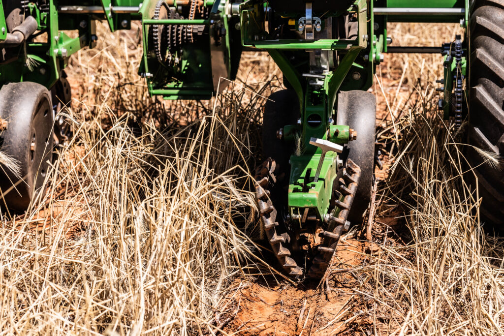 No-till farming equipment moving through crop residue during no-till planting, showing farming implements used for environmentally friendly farming practices.