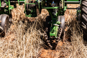 No-till farming equipment moving through crop residue during no-till planting, showing farming implements used for environmentally friendly farming practices.